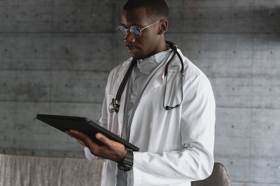 An image of a doctor holding a tablet and examining a medical chart with NLP results. The doctor looks satisfied with the conclusions drawn from the medical data.