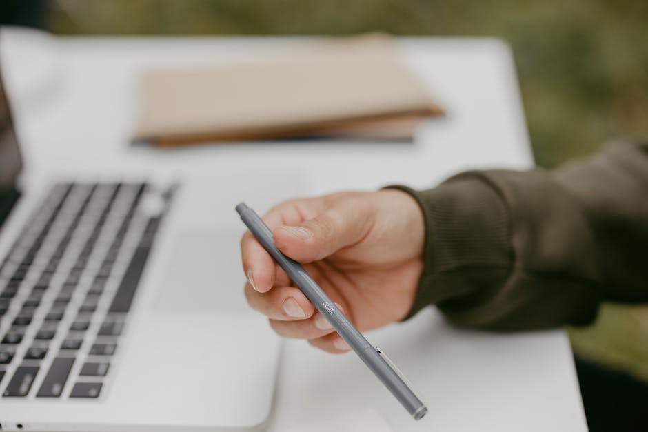 An illustration of a person writing with a pen on a piece of paper.